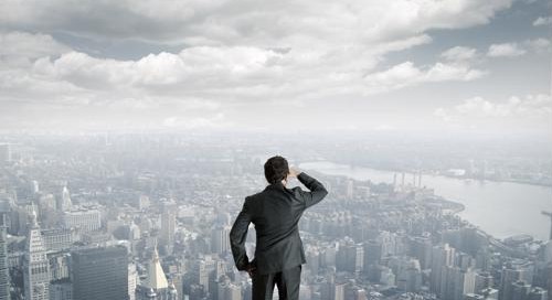 A businessman looks over a cityscape.